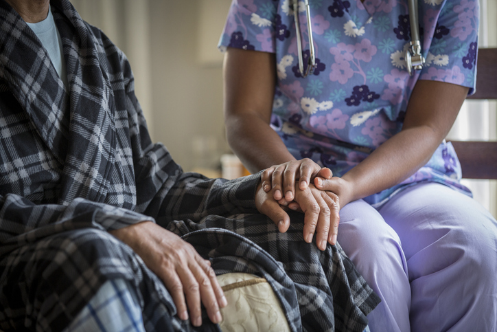 Caregiver holding a patient's hand